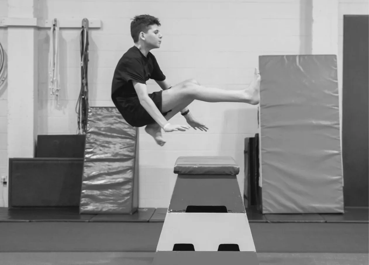 Young person jumping over a vault box during a parkour session